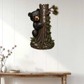 Bear metal wall sign displayed on white wood paneling in a rustic home entryway