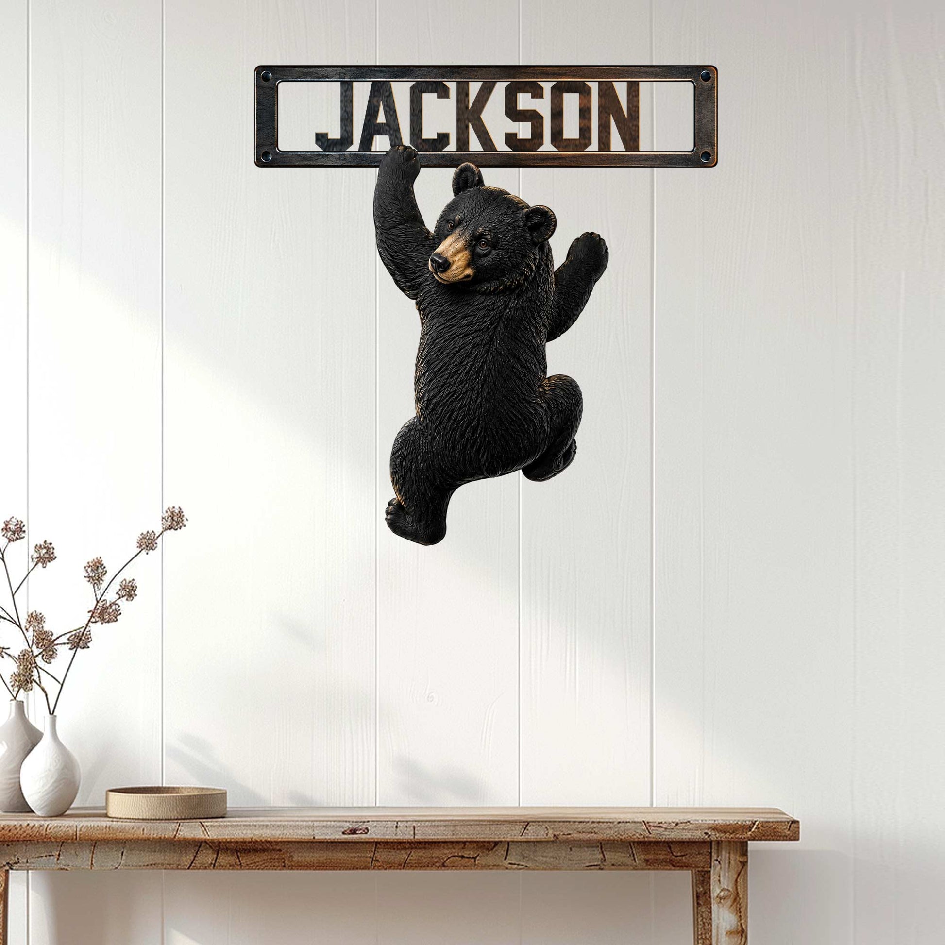 Black bear metal wall sign displayed on white paneled decor in a rustic home setting