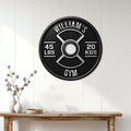 Weight plate gym sign displayed on a white paneled wall above a rustic console table
