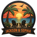 Custom beach house metal sign with tropical palms, sunset ocean view, and two Adirondack chairs