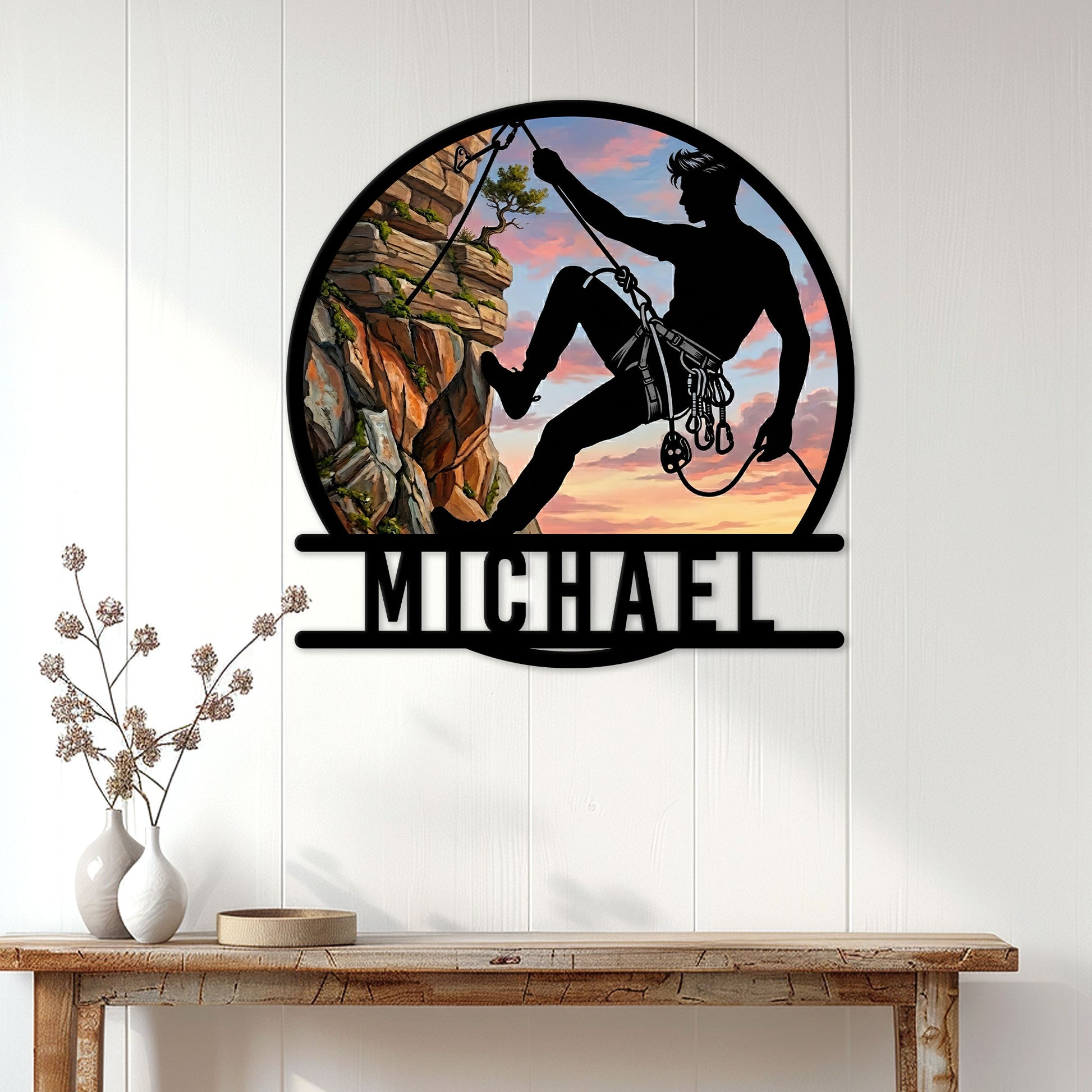 Climber silhouette metal wall sign displayed above a console table in a bright home