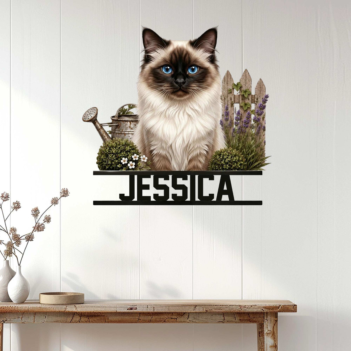 Birman cat wall sign displayed on a light wood-paneled wall above a console table