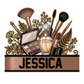 Makeup artist metal sign featuring brushes, an eyeshadow palette, perfume bottle, lipstick, and botanical accents