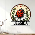 Ladybug garden wall sign displayed on white paneling above a console with floral home decor