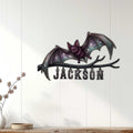 Bat wall decor displayed on a light wood-paneled wall above a console table