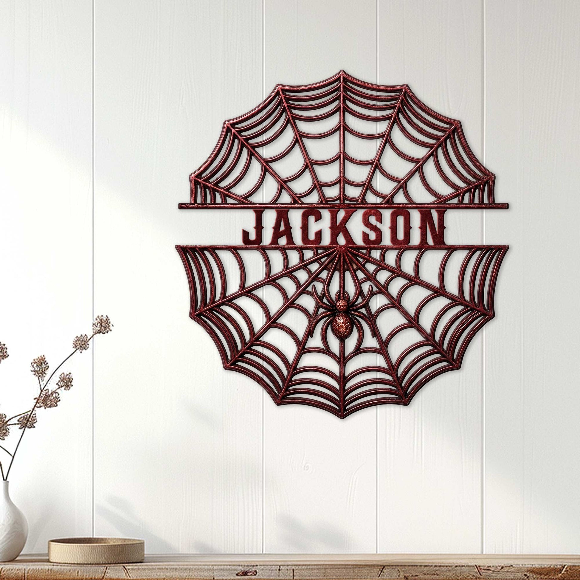 Spider web metal wall sign displayed on a light paneled wall above a console table