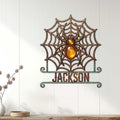 Decorative spider web metal sign displayed on a white paneled wall in a home interior