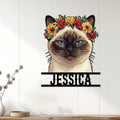 Siamese cat wall sign displayed on a light wood-paneled wall in a cozy home setting
