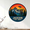 Disc golf wall decor displayed on a white paneled wall with mountain and forest artwork