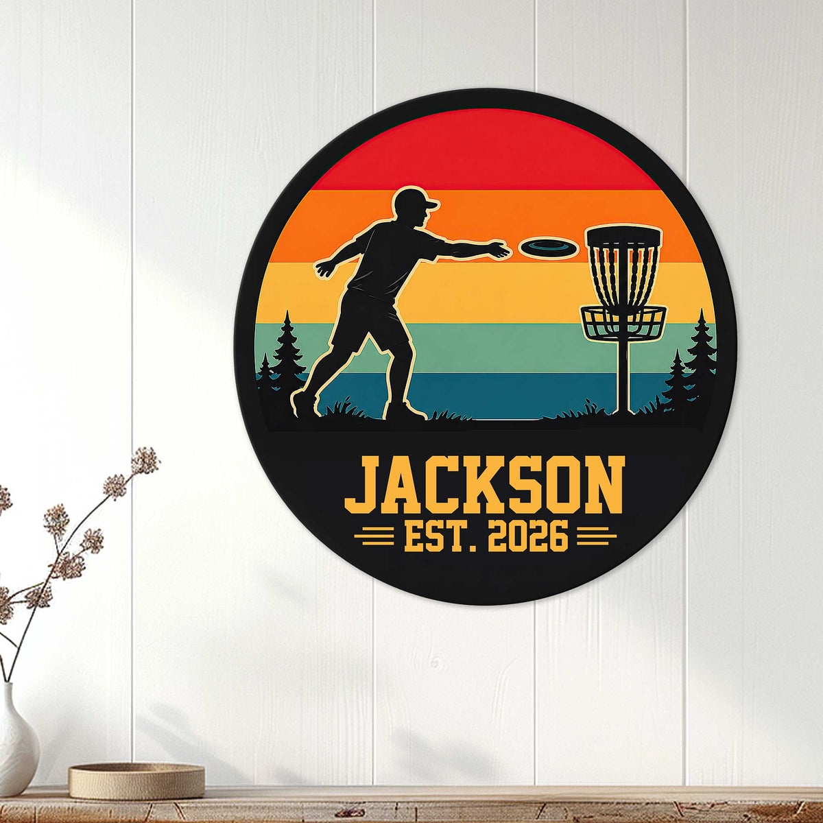 Disc golf metal wall decor displayed on a white paneled wall with a player and basket silhouette