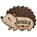 Close-up of a cute hedgehog-shaped metal sign with textured brown quills, a heart and leafy accent