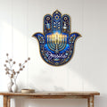 Hanukkah Hamsa wall sign displayed on a light wood-paneled wall above a console table