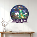 UFO wall decor displayed on a white paneled wall, featuring a glowing tractor beam over a countryside farmhouse