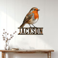 Robin metal wall sign displayed on a white paneled wall above a console table