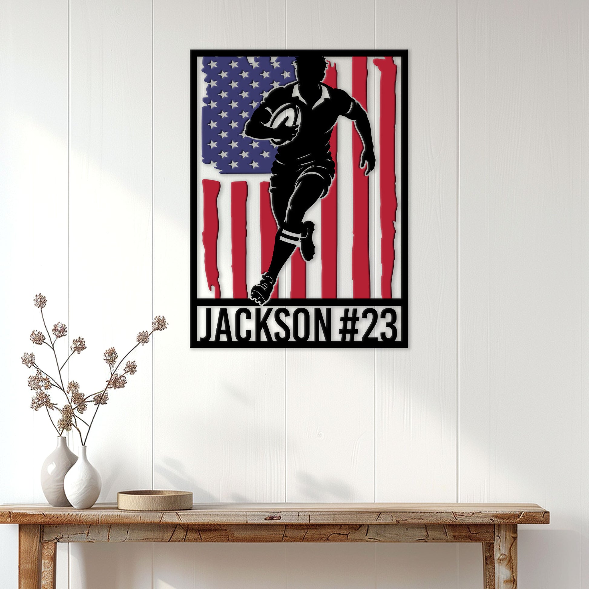 Patriotic rugby wall sign displayed on a white paneled wall above a console table