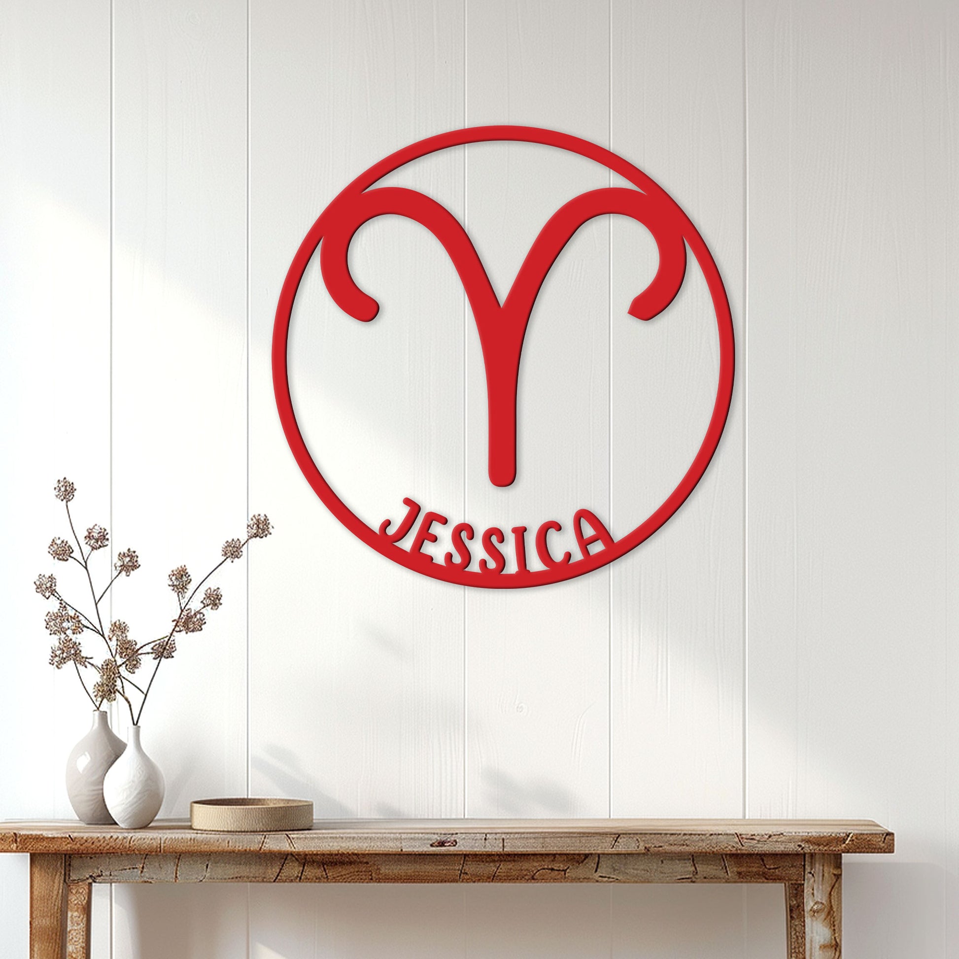 Red Aries zodiac symbol metal sign displayed on a bright paneled wall above a console table