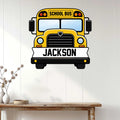 Custom school bus wall sign displayed above a console table in a bright, white-paneled room