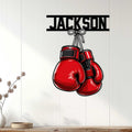 Red boxing gloves wall sign displayed on a light wood-paneled wall in a modern home setting