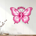 Pink butterfly breast cancer ribbon wall sign displayed on a light wood-paneled wall