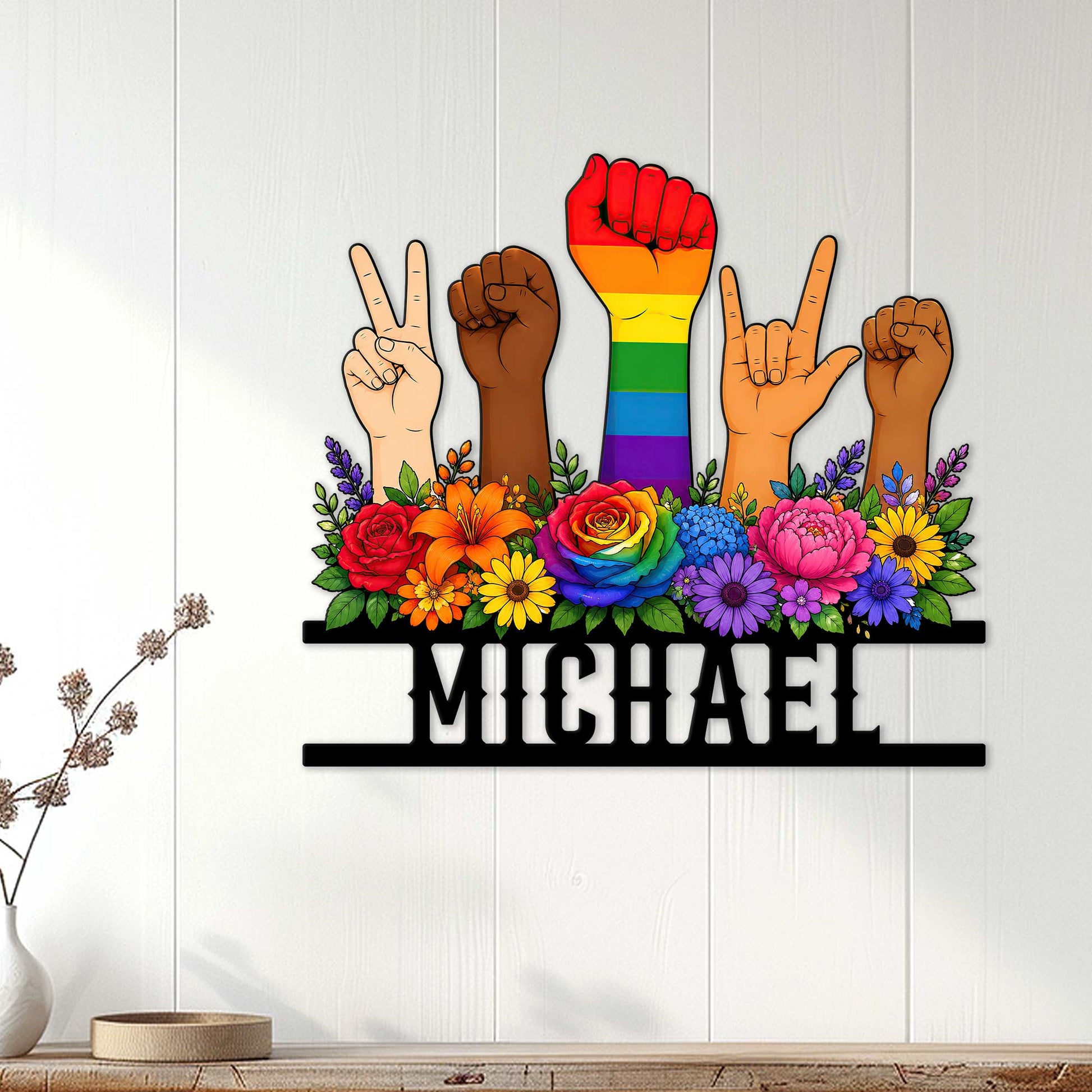 Pride wall decor displayed on a light wood-paneled wall with diverse raised hands and vivid rainbow flowers
