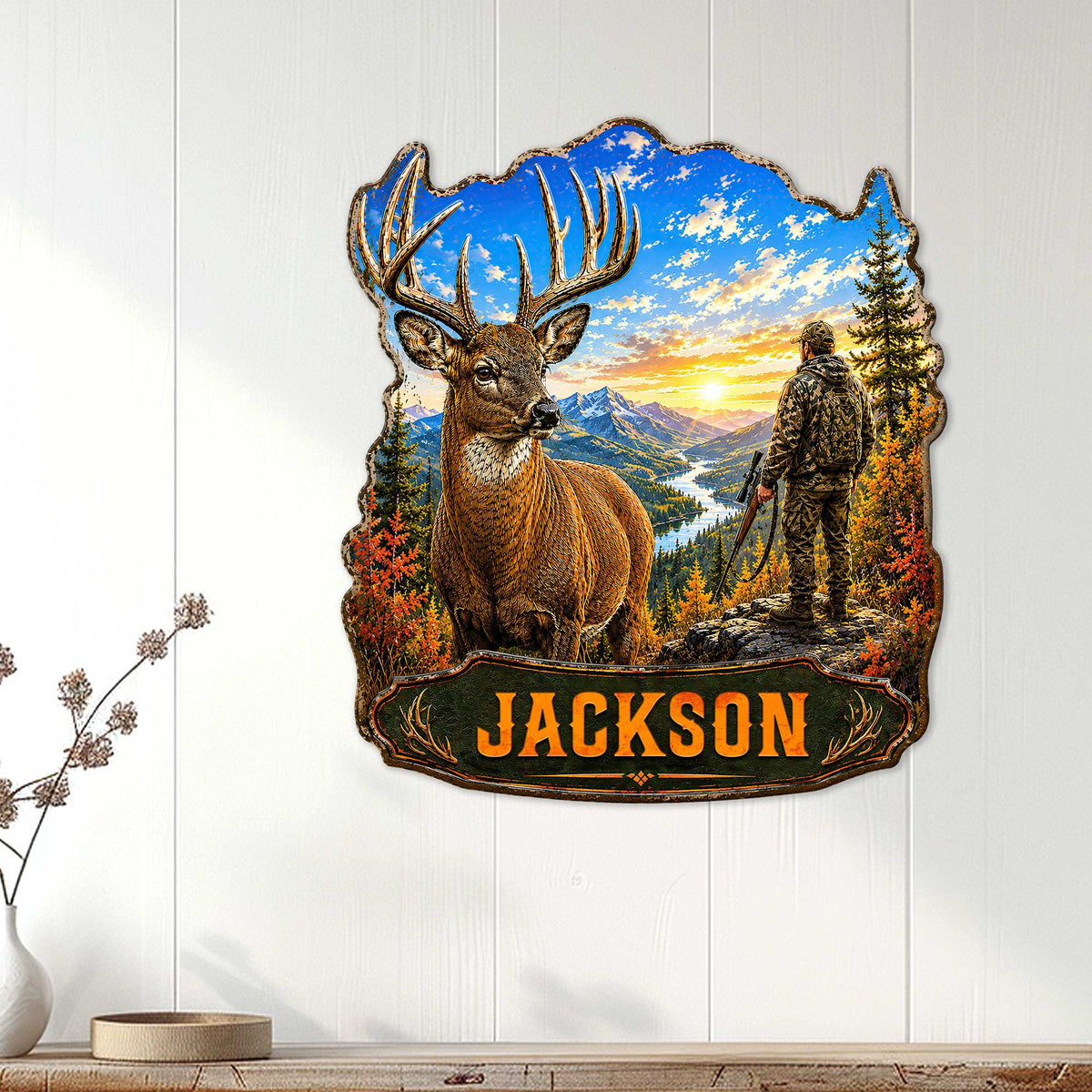 Deer hunter metal wall sign displayed on white paneling with a buck and mountain landscape