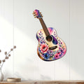 Floral guitar wall sign displayed on a light wood-paneled wall in a bright home setting