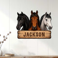 Horse wall sign displayed on a light wood-paneled wall, featuring three realistic horse heads
