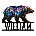 Colorful bear-shaped metal sign featuring mountain peaks, evergreen forest, moonlit sky, and bold black framing