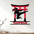 Close-up karate wall sign with a female martial artist silhouette and bold red and black torii design