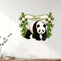 Bamboo panda metal wall art displayed on a light wood-paneled wall in a cozy home setting