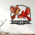 Cardinal couple metal wall sign displayed on a light wood-paneled wall in a home setting