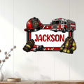 Firefighter wall sign displayed on a light wood wall, featuring a fire truck, helmet, gloves, hose, and protective coat