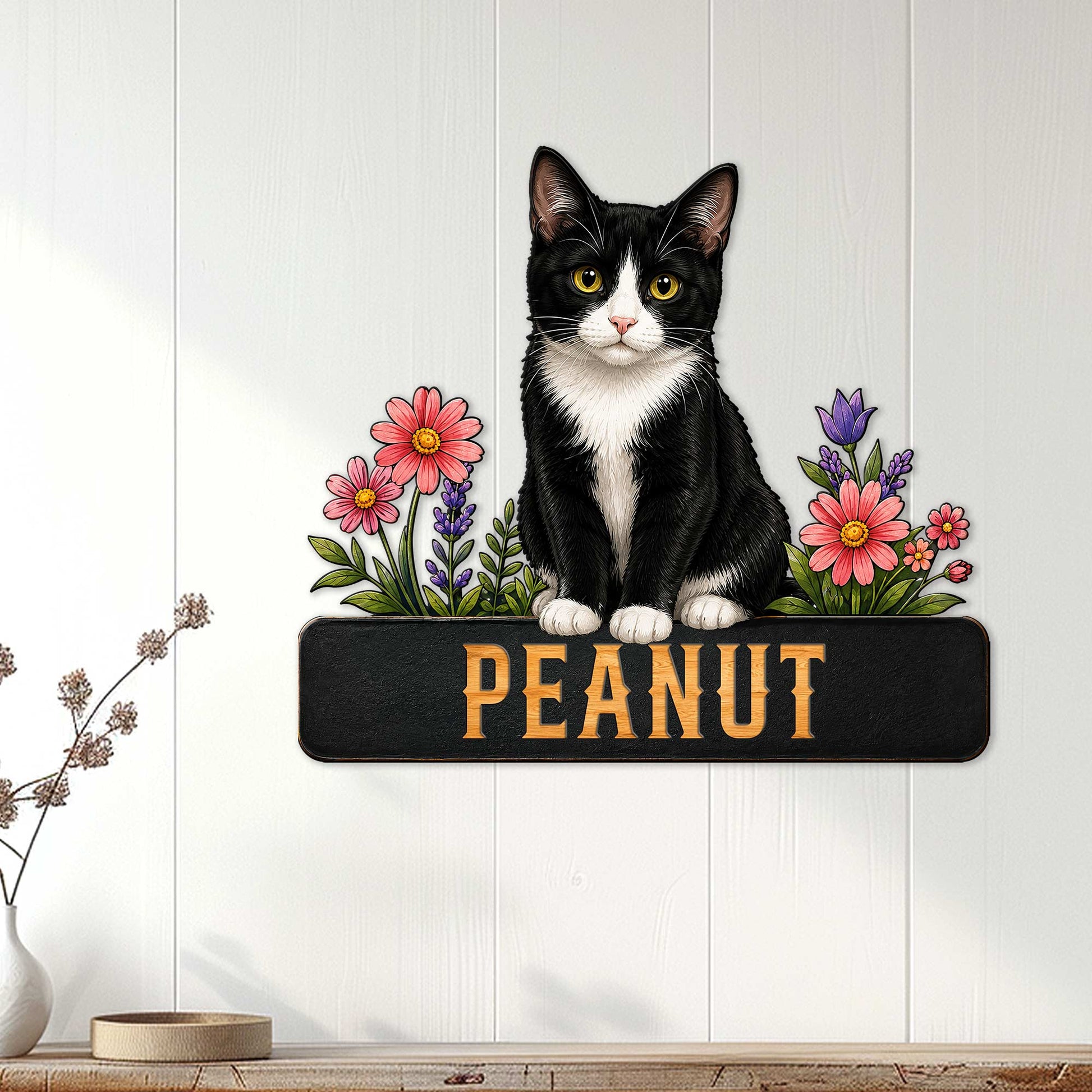 Tuxedo cat wall sign displayed on a light wood-paneled wall above a console table