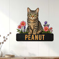 Tabby cat wall sign displayed on a light paneled wall above a console with floral cat artwork