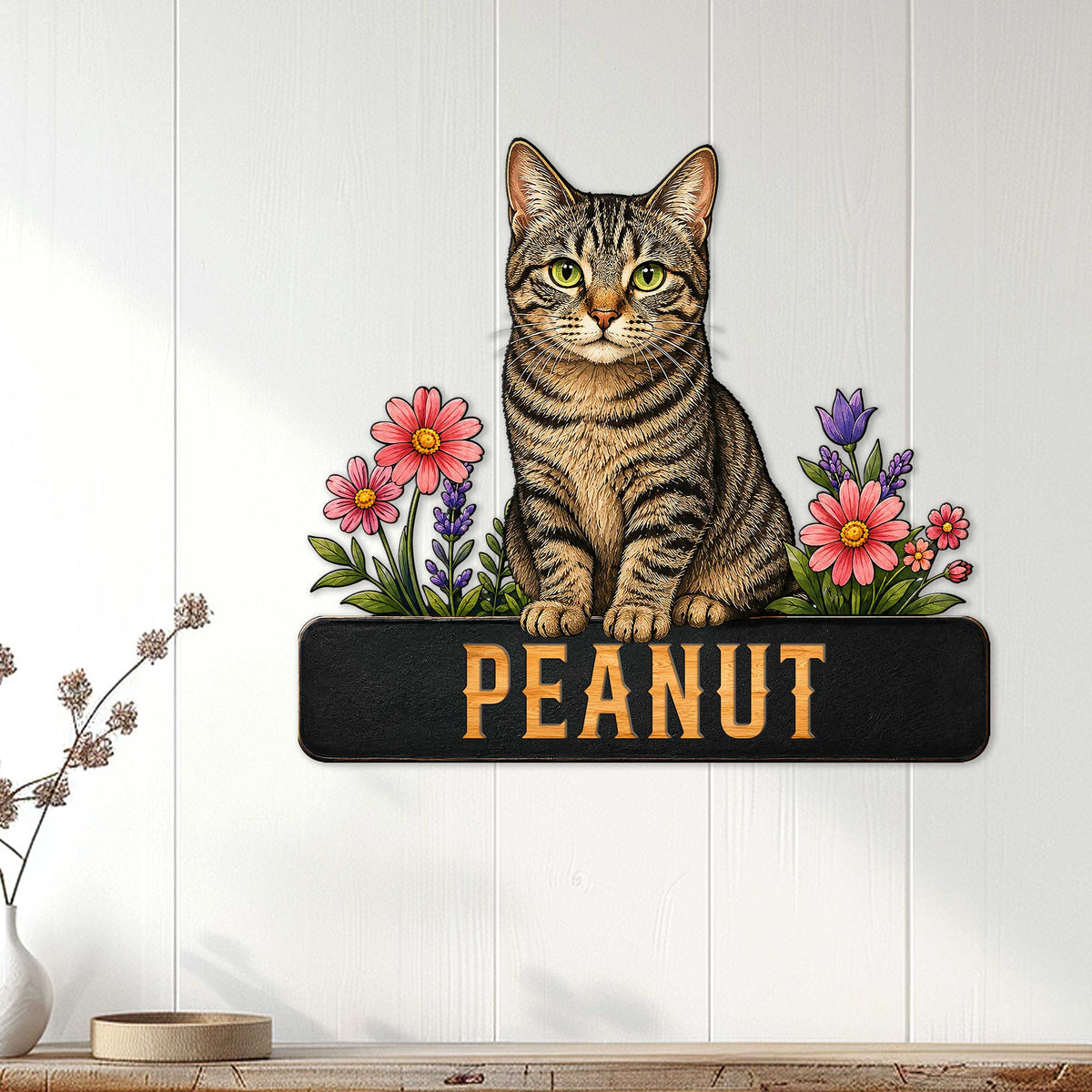 Tabby cat wall sign displayed on a light paneled wall above a console with floral cat artwork