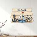 Nautical family metal sign displayed on a light wood wall with sailboat, anchor, and ship wheel artwork