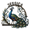 Ornate peacock metal sign featuring a vibrant blue bird, flowing tail feathers, floral vines, and a circular frame
