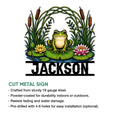 Cut metal frog sign featuring a cheerful frog surrounded by pond plants and water lilies