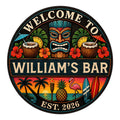 Round tiki bar metal sign with a carved tiki mask, tropical drinks, hibiscus flowers, and beach sunset artwork