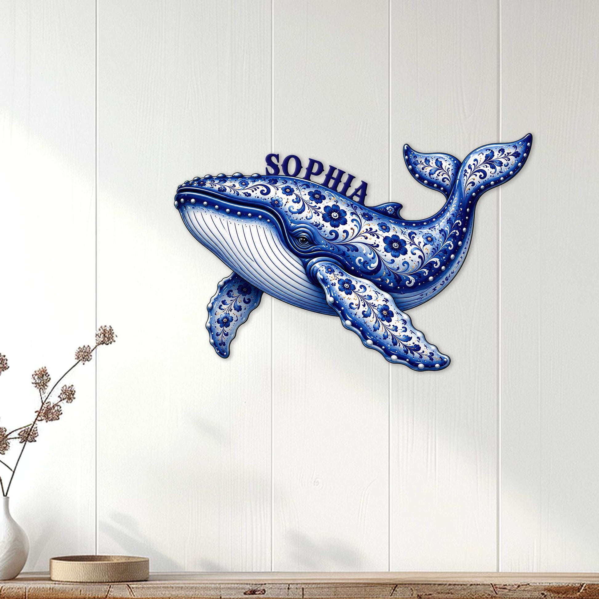 Ornate whale wall decor displayed on a light wood-paneled wall in a bright coastal-style room