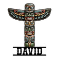 Native-inspired totem pole metal sign with stacked carved faces, colorful wings, and bold decorative detailing