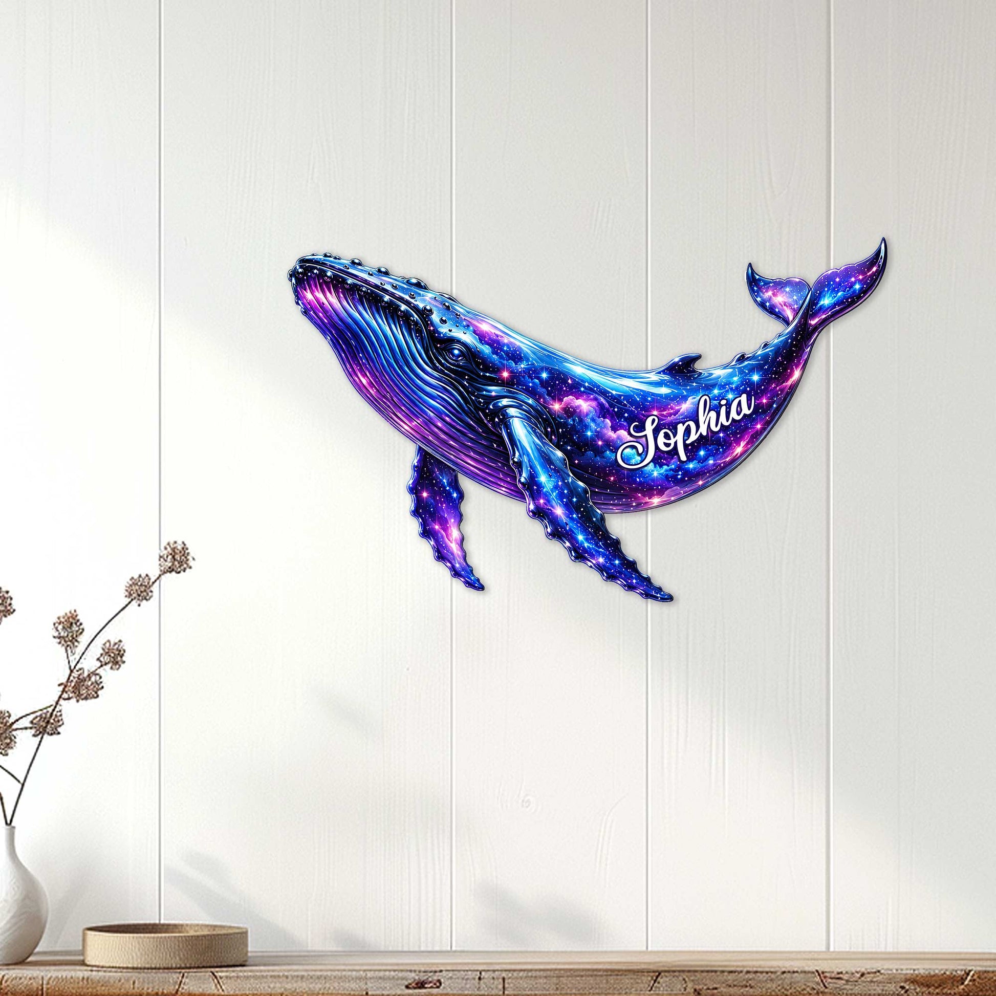 Vibrant galaxy whale metal wall sign displayed on a white wood-paneled wall in a bright living space