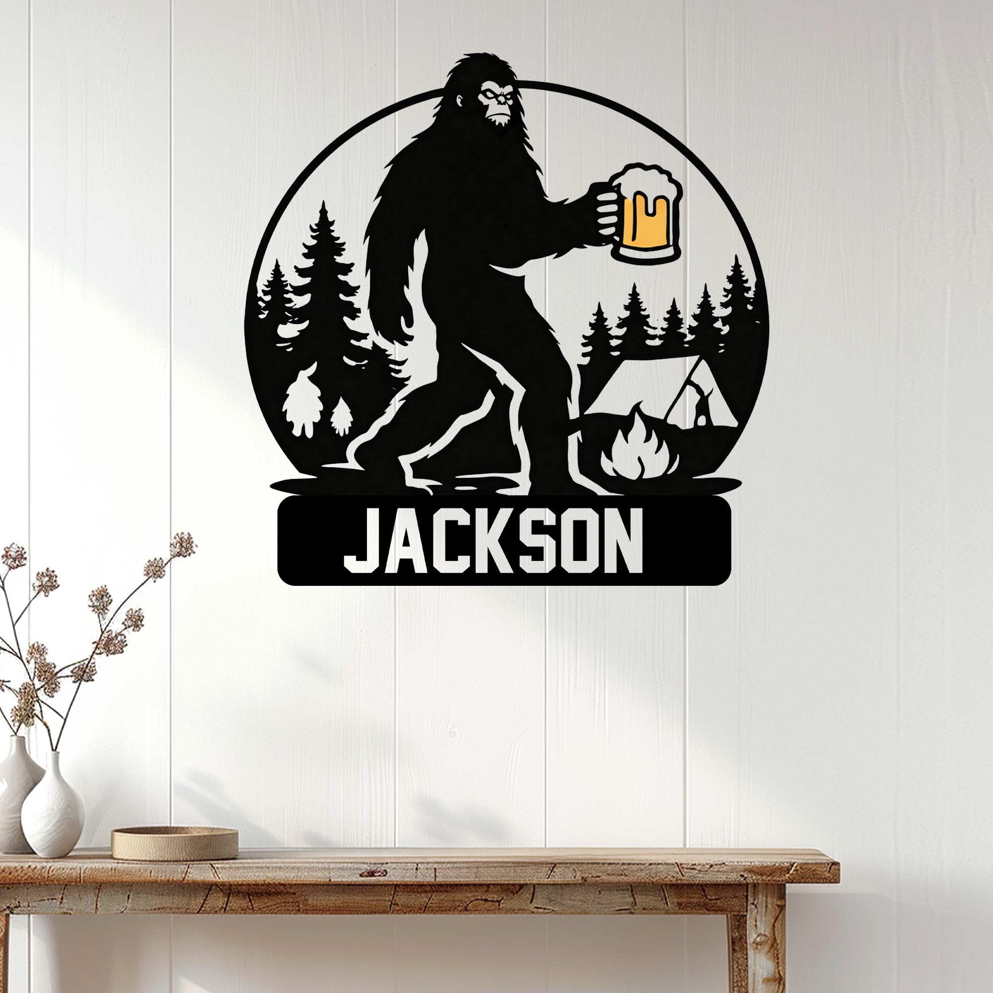 Bigfoot metal wall sign displayed on a light wood-paneled wall above a rustic console table