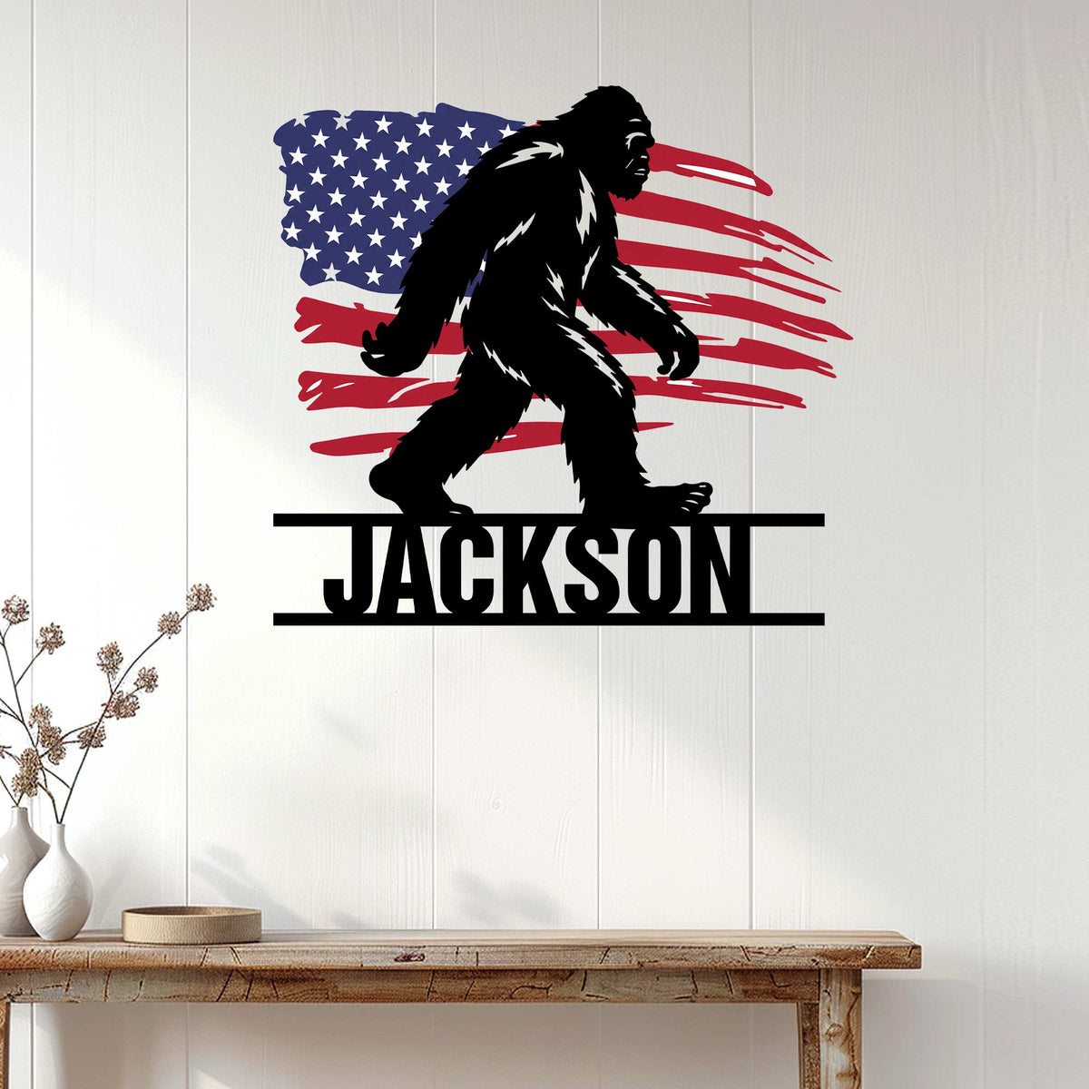 Patriotic Bigfoot metal sign displayed as rustic wall decor against a bright white paneled wall