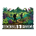 Custom trekking metal sign with two hikers on a jungle trail beneath tropical mountains and colorful birds