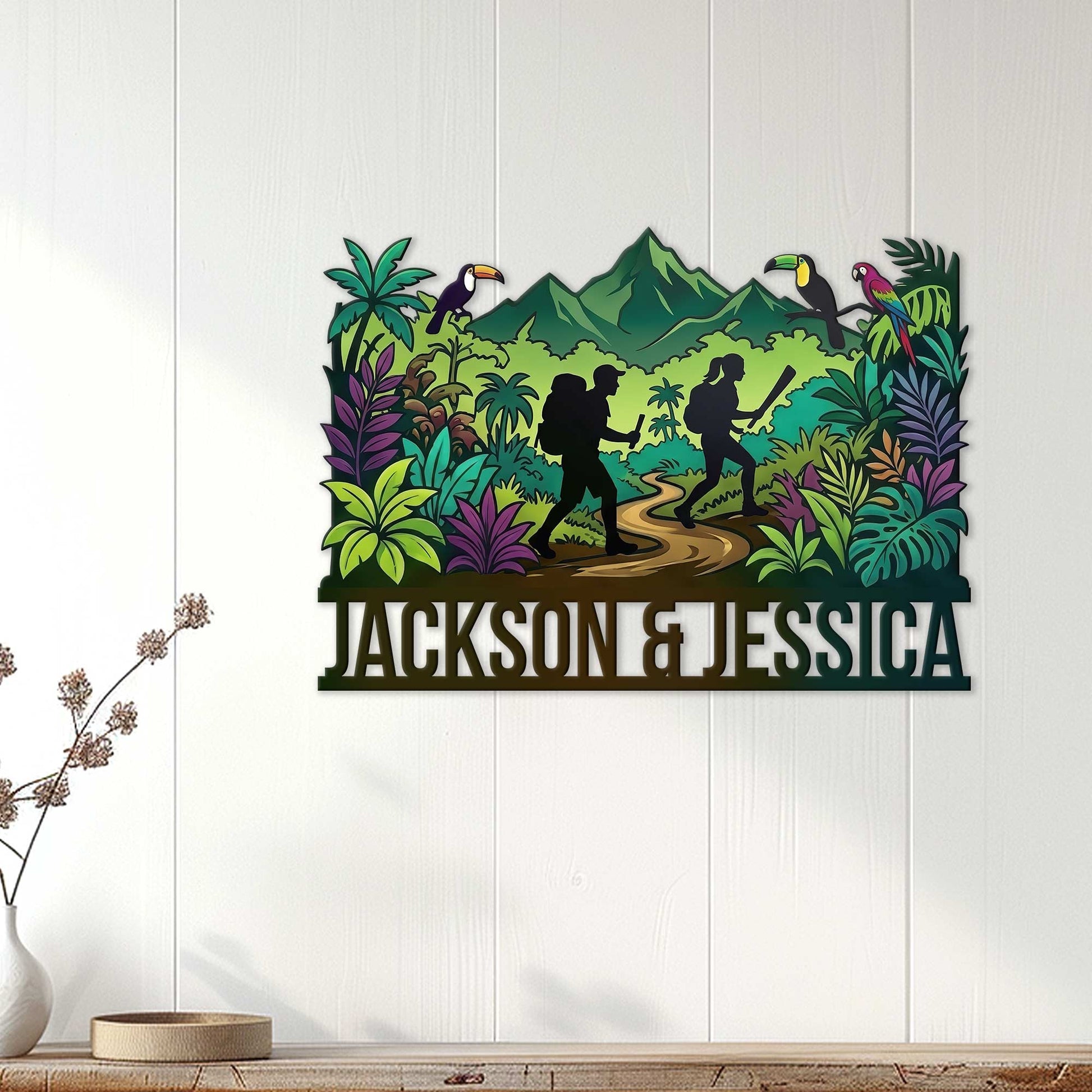 Trekking wall decor displayed on a light wood wall, featuring hikers, tropical foliage, birds, and mountains