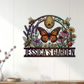 Pollinator garden metal sign displayed on a white paneled wall with colorful flowers, bees, and butterfly artwork