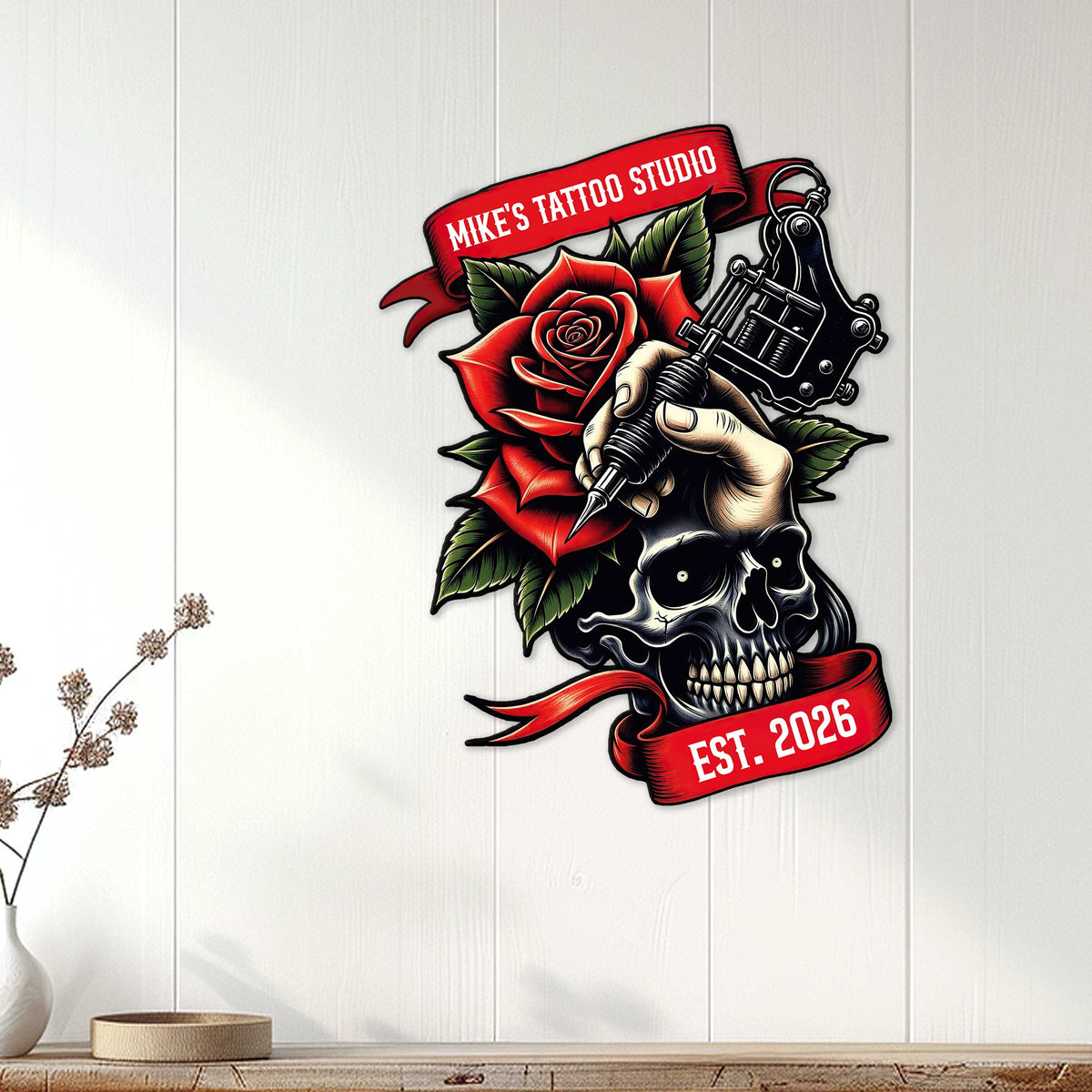 Tattoo studio wall decor displayed on white paneling, featuring a skull, rose, and tattoo machine