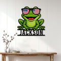 Frog metal wall sign displayed on a bright paneled wall above a console table