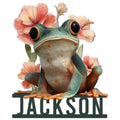Colorful frog metal sign featuring a wide-eyed frog surrounded by coral flowers and leafy botanical details